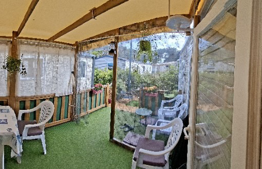 Covered veranda with chairs on the garden side